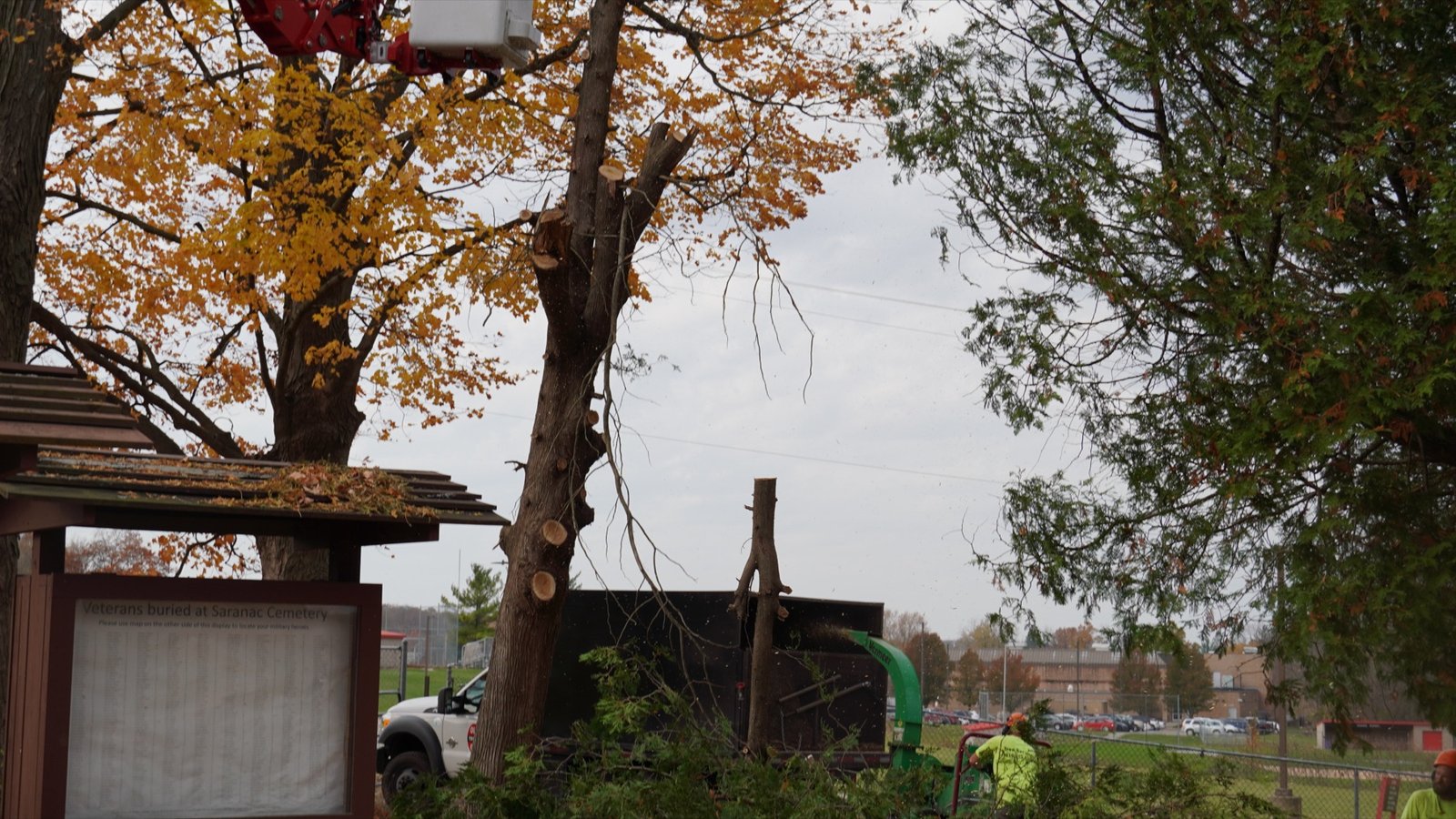 An Ole Man RB's crane lifting a large tree section over a West Michigan home during removal